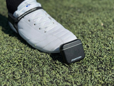 Avtiare white cleats and Playermaker on a turf soccer field.