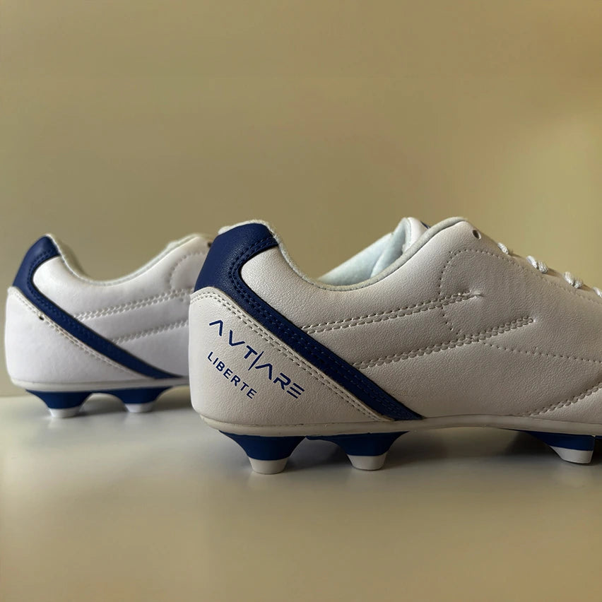 Avtiare Classico White soccer cleats with blue accents on a white surface.